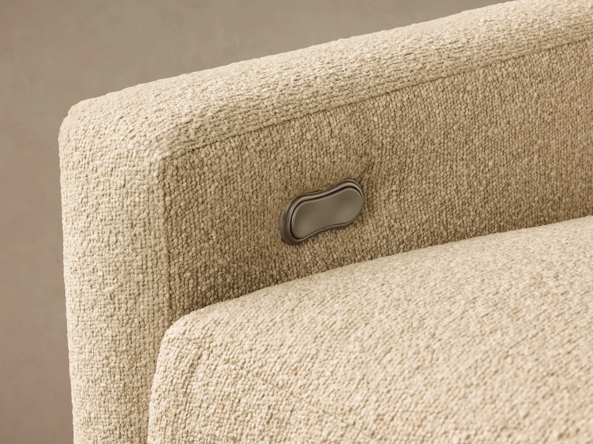 Close-up of the beige textured Kipton Slope Arm Three-Piece Motion Chaise Sectional, showing a silver motion control button.