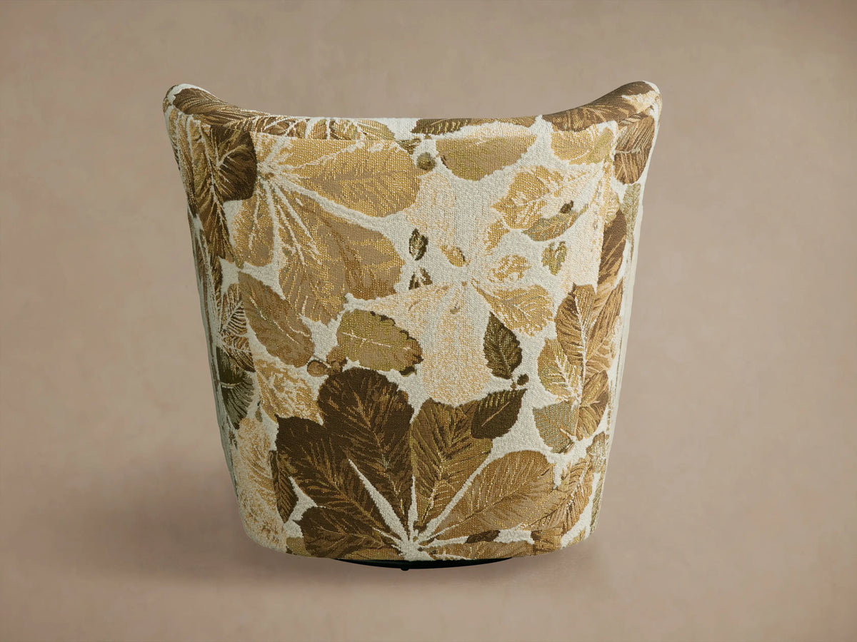 Sasha Swivel Chair with a leaf-patterned fabric in shades of brown and beige. The chair features a curved backrest and seat, showing a side view.