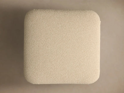 Close-up of a creamy beige textured cushion with subtle pleating, on a round, brushed bronze metallic base.
