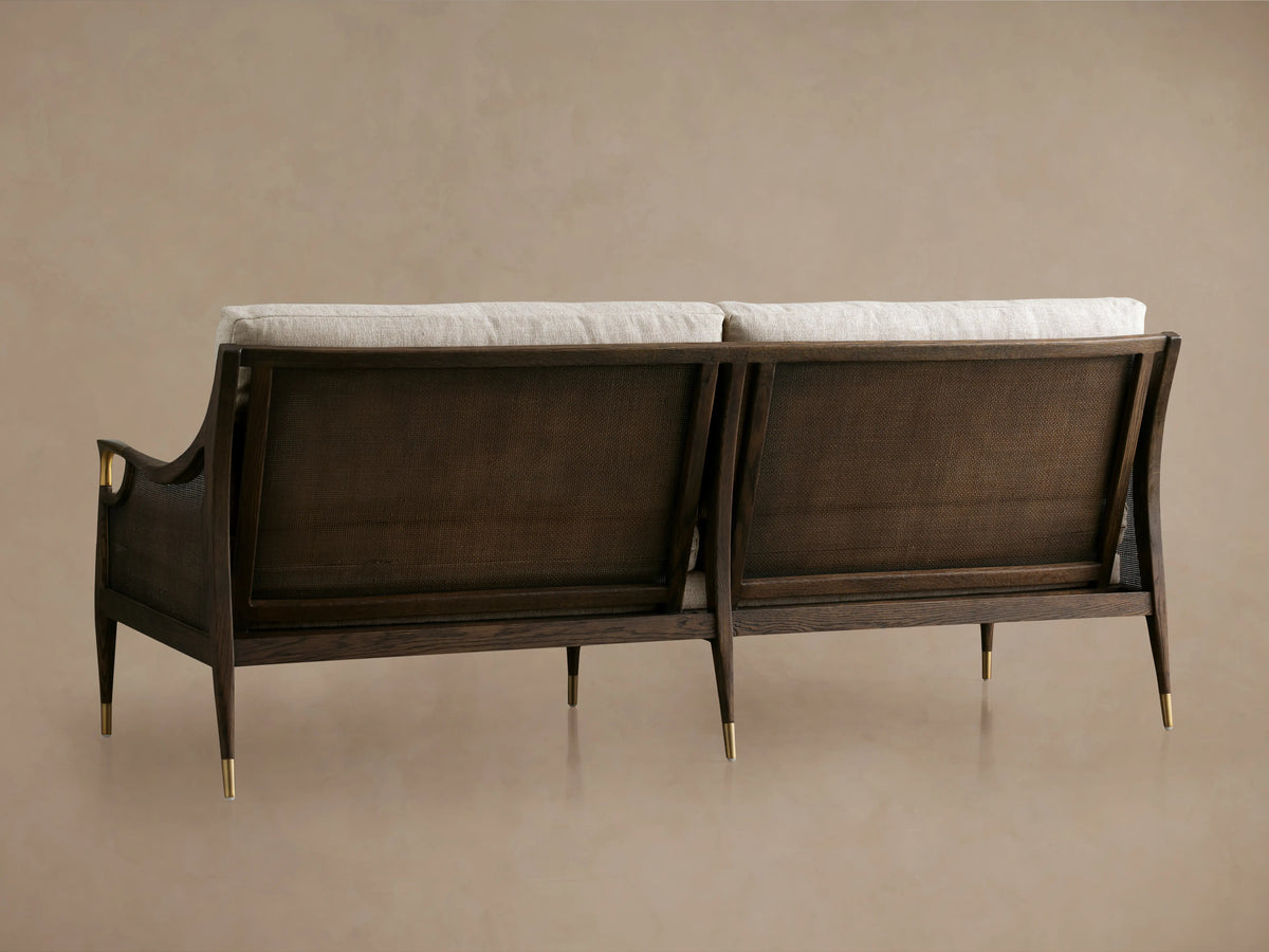 Fisher Cane Back Sofa with red oak wood frame in mocha finish, cane backrests, and white cushions, viewed from the back.