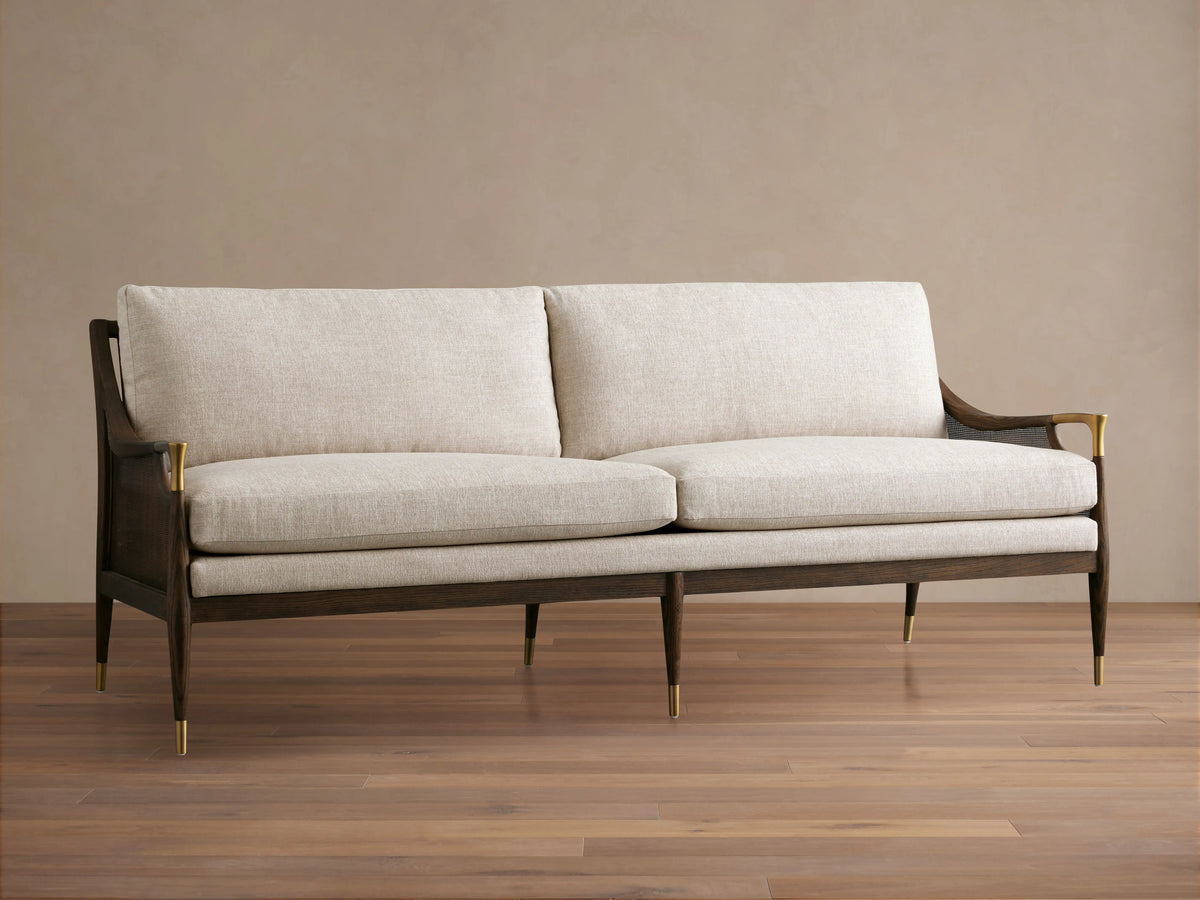 Fisher Cane Back Sofa in a mocha-finished red oak frame with beige cushions, gold accents, and tapered legs on a wooden floor.