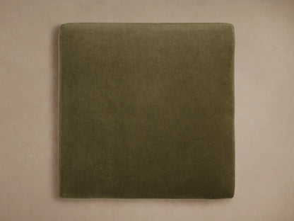 Green Fisher Square Ottoman corner with soft cushion, mocha-finished oak wood legs, and brass accents, on beige background.