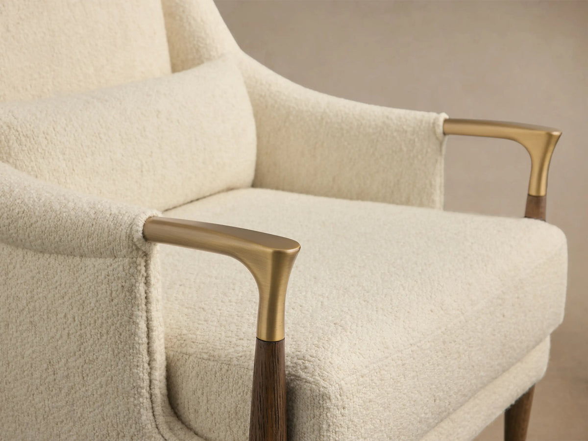 Front view of a cream Fisher High-Back Chair with textured upholstery, dark wood legs with gold accents, and a matching lumbar pillow.