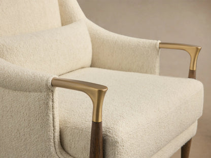 Front view of a cream Fisher High-Back Chair with textured upholstery, dark wood legs with gold accents, and a matching lumbar pillow.