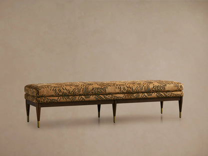 Fisher Bench with mocha-finished red oak frame, camel-colored cushion with abstract black pattern, set on a wooden floor.