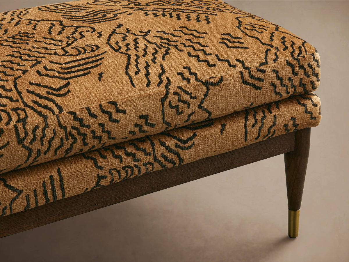 Fisher Bench with mocha-finished red oak frame and patterned fabric cushion. Tapered legs with brass tips, placed on a neutral background.