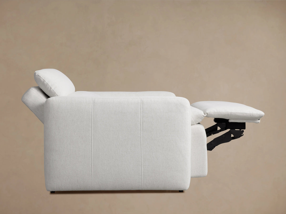 Close-up of a Rowland Tailored High-Back Motion Recliner in light grey textured fabric, showing arm, seat, and back with two control buttons.