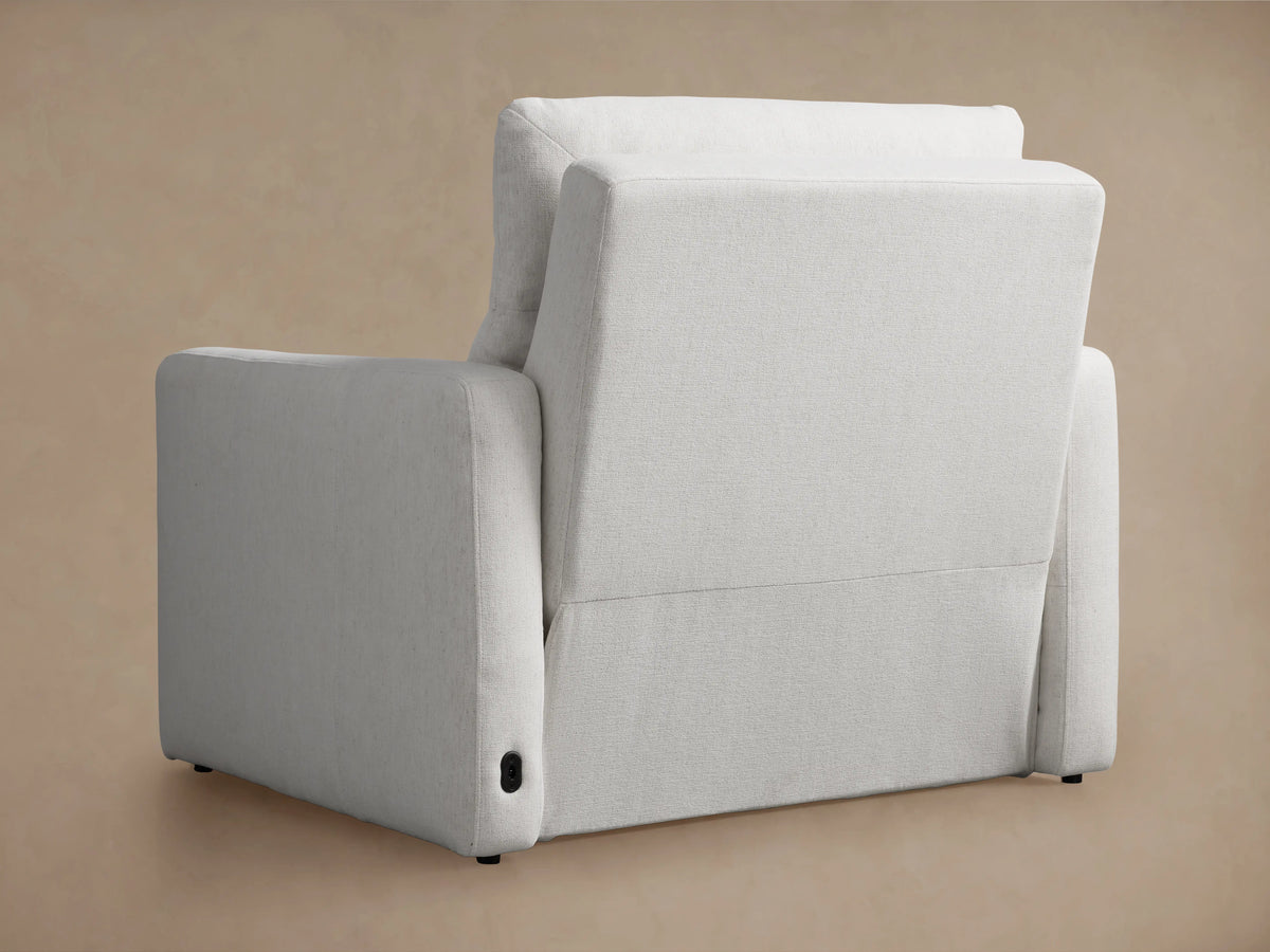 Rowland Tailored High-Back Motion Recliner, white, partially reclined with footrest extended, viewed from side against beige wall.