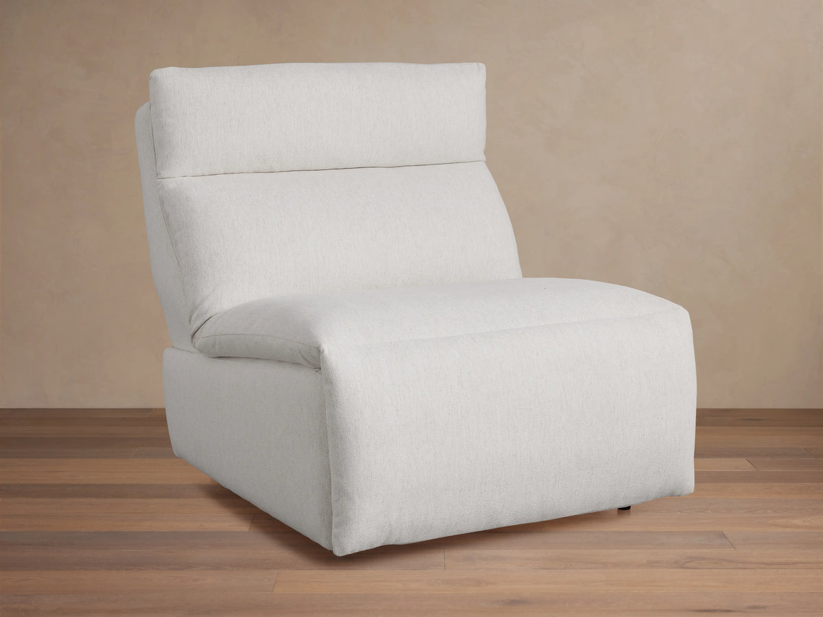 Rowland Tailored 34" Armless Motion Recliner, light grey tailored fabric, plush cushions, angled right on wood floor.