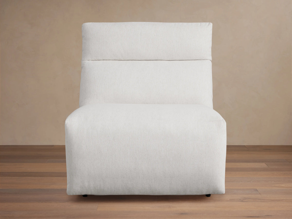 Rowland Tailored 34" Armless Motion Recliner, light grey tailored fabric, plush cushions, angled right on wood floor.