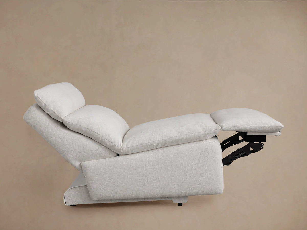 Rowland Tailored Armless Motion Recliner close-up. Off-white textured fabric, showing seat cushion, backrest, and silver control buttons.
