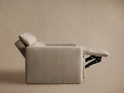 Angled close-up of a light beige Rowland Tailored High-Back Motion Recliner, showing its textured fabric, armrest, and tailored seams.