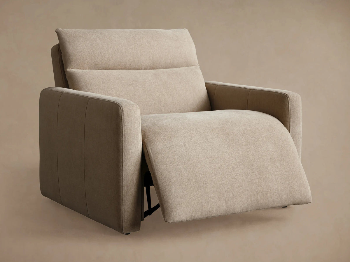 Beige Rowland Tailored High-Back Motion Recliner, side view, fully reclined with footrest extended against a tan wall.