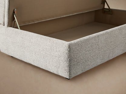 Light cream Kipton Storage Ottoman, rectangular with a plush, domed top cushion and textured fabric, in an angled view.
