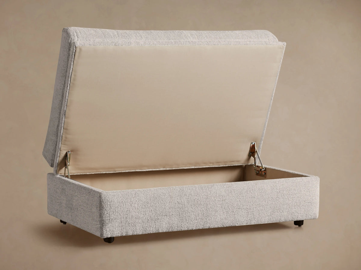 Light gray Kipton Storage Ottoman with textured fabric, soft rounded top cushion, and rectangular base, shown from an angle.