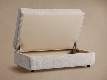 Light gray Kipton Storage Ottoman with textured fabric, soft rounded top cushion, and rectangular base, shown from an angle.
