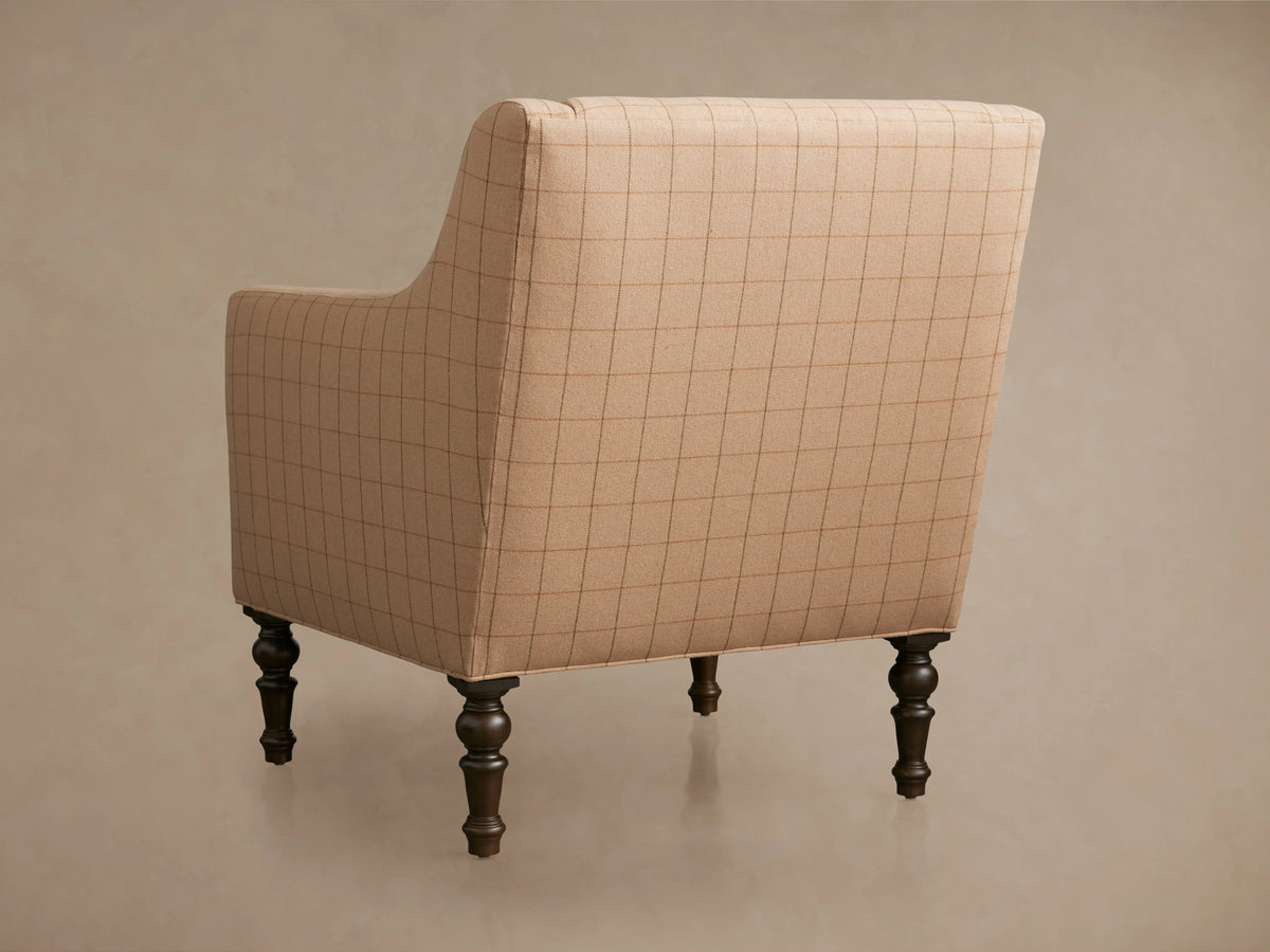 Fenwick Chair with a light brown, checked fabric. Features button-tufted seat cushion and dark wooden legs on a neutral background.