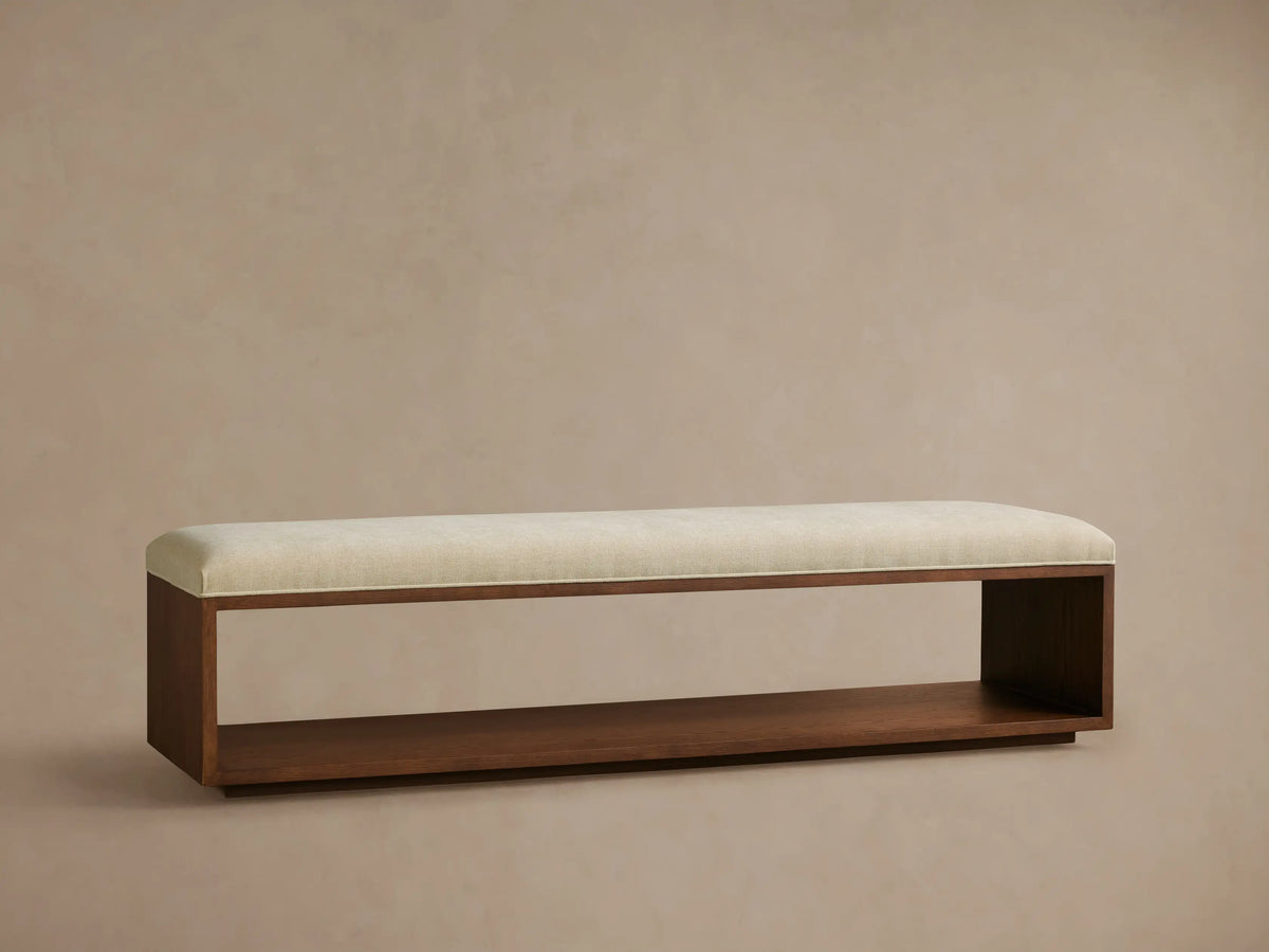 Close-up of Taya Bench showing a thick, textured light beige cushion resting on a dark mocha brown wood frame with visible grain.