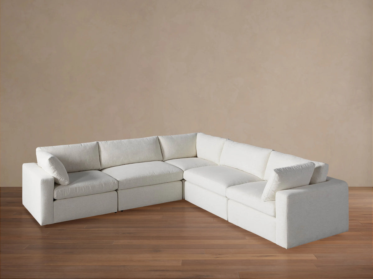 Beale Five-Piece Corner Sectional in off-white fabric, L-shaped with plush cushions, on wooden floor against a beige wall.