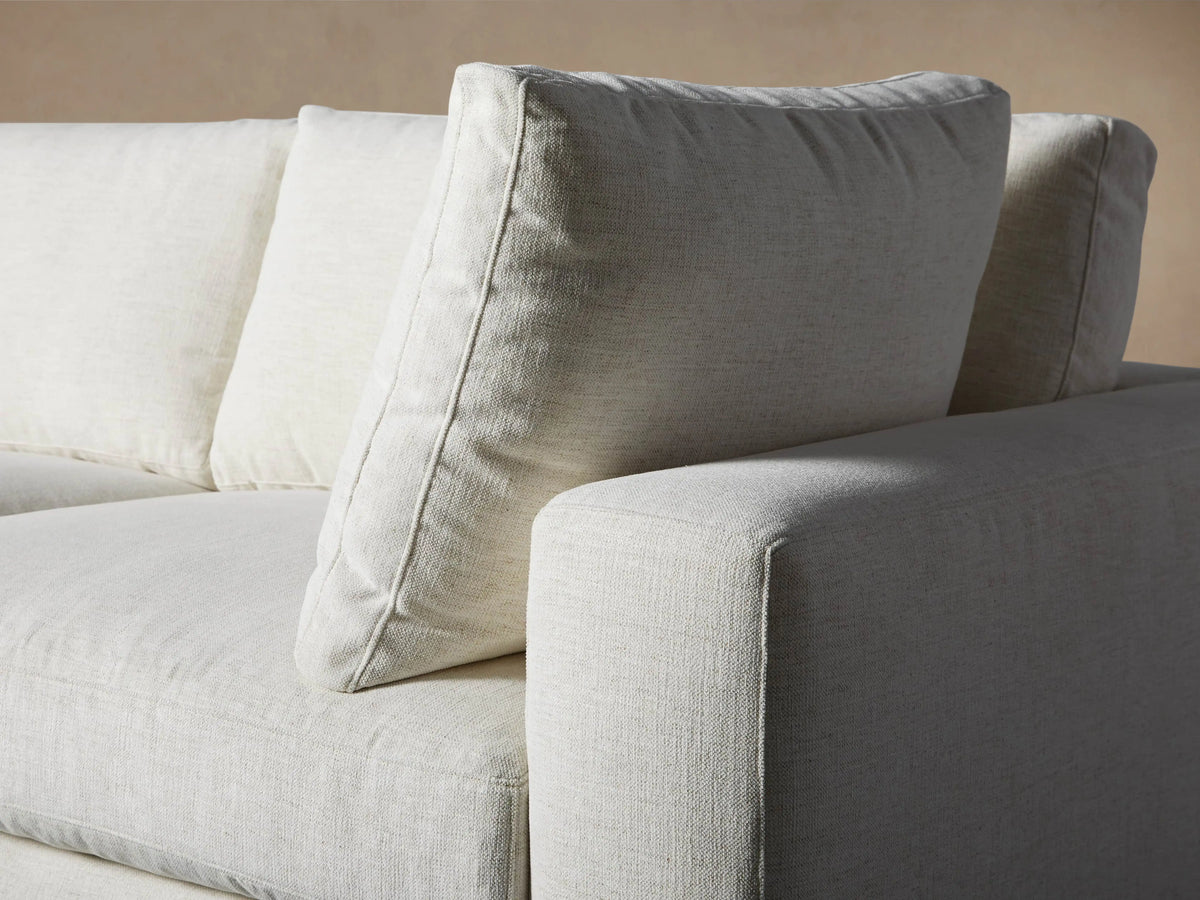Beale Five-Piece Corner Sectional, L-shaped, in light cream fabric with plush cushions and wide arms, on wooden floor.