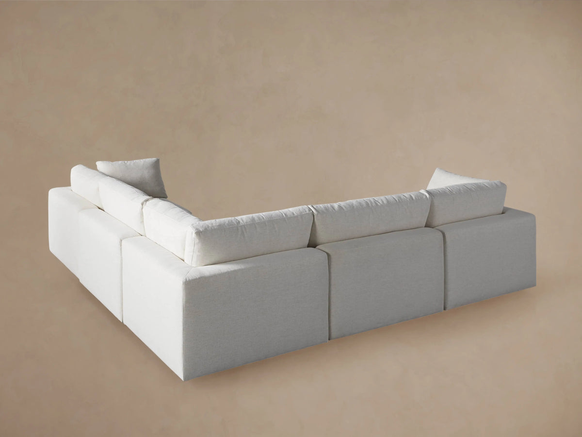 Close-up of Beale Five-Piece Corner Sectional's light, textured beige fabric back cushion and rolled-edge lower frame.