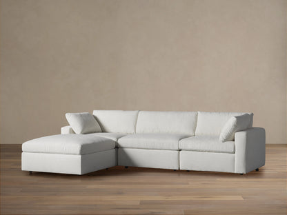 Light gray fabric Beale Four-Piece Sectional with plush cushions, a left chaise, on wood floor against a neutral wall.