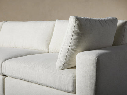 Light gray Beale Four-Piece Sectional sofa with left-facing chaise, shown angled on a wooden floor against a plain wall.