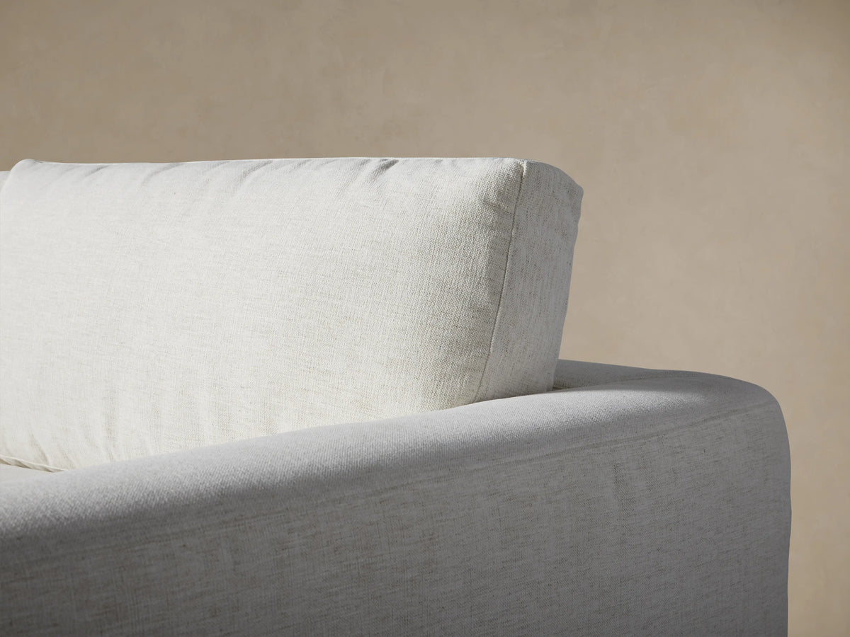 Close-up of Beale Four-Piece Sectional in light gray fabric. Plush seat, back cushions, and squared armrest show casual comfort.
