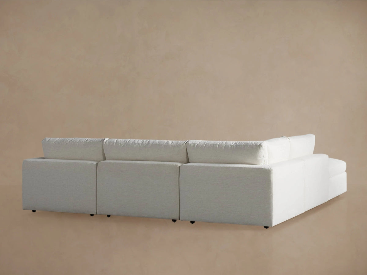 Close-up of a Beale Five Piece Sectional's light, textured off-white back cushion & seat, angled view against a soft wall.
