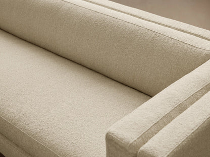 Light beige modern textured fabric sofa with a low back, subtly recessed arms, and slender gold legs, on a wood floor.