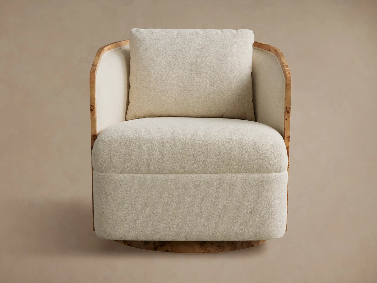 Cream Tilda Swivel Chair with textured boucle-like upholstery, a burl wood frame, and a matching pillow, viewed from the front.