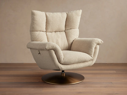 Deacon Swivel Recliner in beige fabric, with high cushioned backrest, curved armrests, and a bronze swivel base on wooden floor.