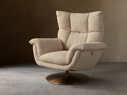 Deacon Swivel Recliner in beige fabric, with high cushioned backrest, curved armrests, and a bronze swivel base on wooden floor.