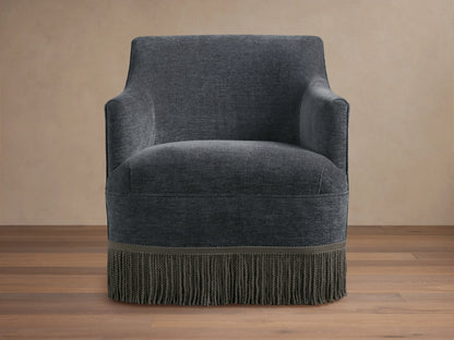 Savannah Swivel Chair in dark gray fabric, featuring a rounded back, sleek armrests, and a decorative fringe at the base.