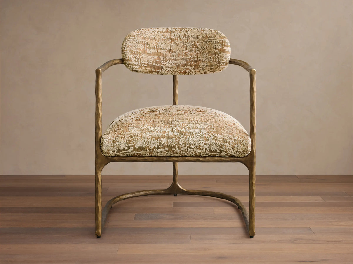 Front view of the Nataly Chair with a textured light brass frame and gold and cream patterned upholstery.