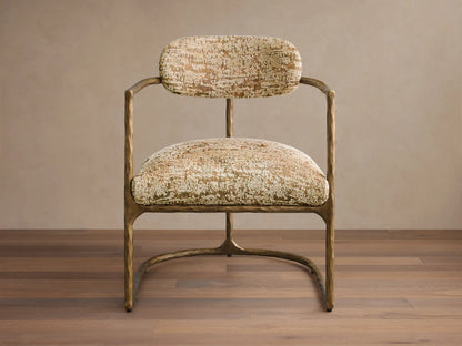 Front view of the Nataly Chair with a textured light brass frame and gold and cream patterned upholstery.
