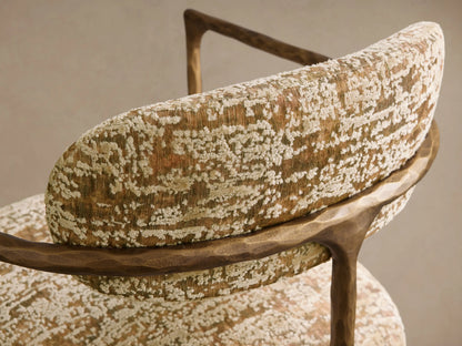 Front view of the Nataly Chair with gold and green patterned upholstery, featuring an exposed textured light brass frame.