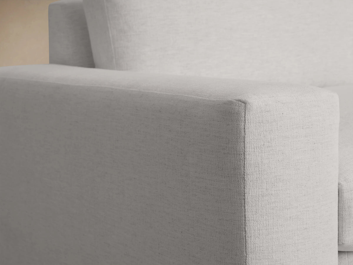 Kipton Wide Arm Sofa in light gray fabric, showcasing a close-up of a wide armrest with smooth texture and minimalist design.