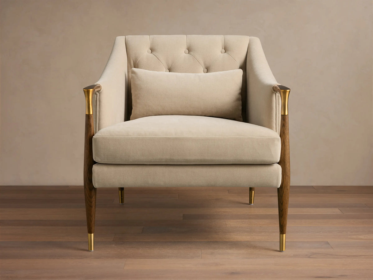Front view of cream Fisher Club Chair with a tufted back, lumbar pillow, dark wood frame, and brass leg/arm accents.