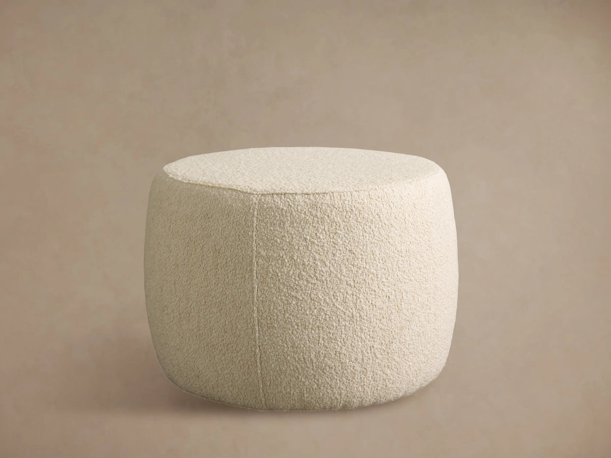 Close-up of Ryles Ottoman showing its plush, textured cream-colored boucle fabric upholstery with a curved seam.