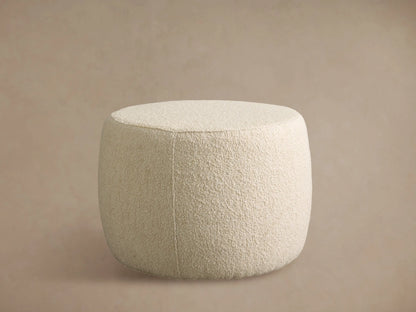 Close-up of Ryles Ottoman showing its plush, textured cream-colored boucle fabric upholstery with a curved seam.