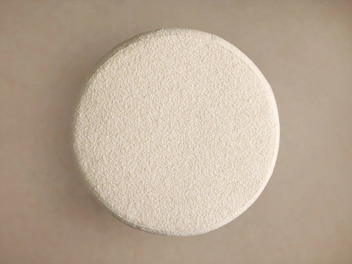 Ryles Ottoman, cream, round, barrel-shaped, upholstered in textured bouclé fabric, centered on a neutral background.