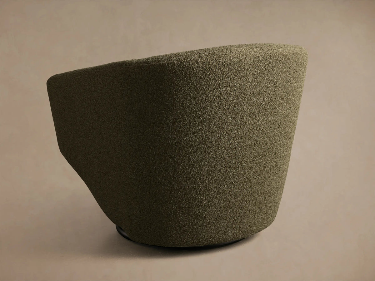 Close-up of the dark olive green bouclé fabric on the Pelton Swivel Chair, showing the curved backrest and seat cushion.