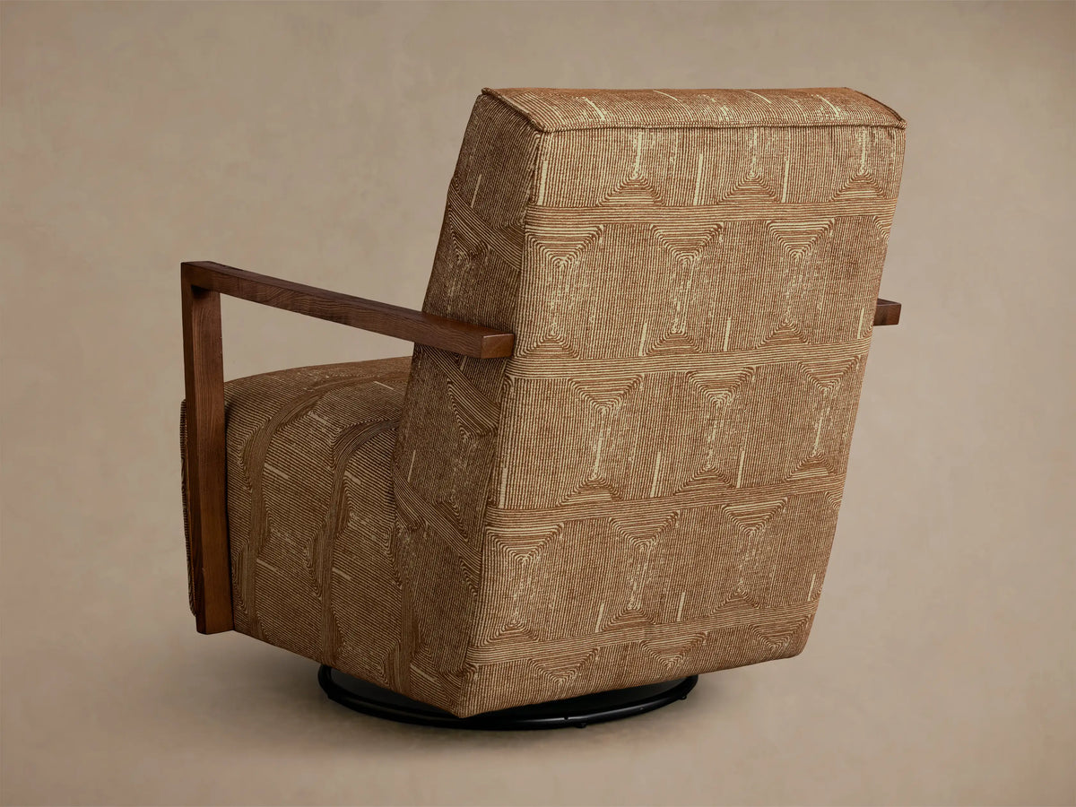 Close-up of the beige geometric pattern on the brown upholstery and dark wood armrest of the Walsh Swivel Glider.