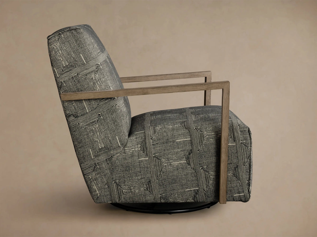 Side-back view of a Walsh Swivel Glider upholstered in black and off-white nested geometric line pattern fabric with light brown wooden arms.
