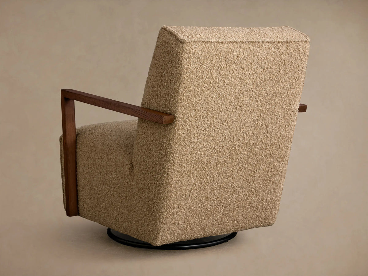 Close-up of the textured beige bouclv© fabric and dark wood armrest of the Walsh Swivel Glider.