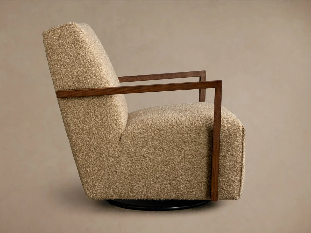 Rear-side view of a tan textured Walsh Swivel Glider with dark brown wooden armrests and a black circular swivel base.
