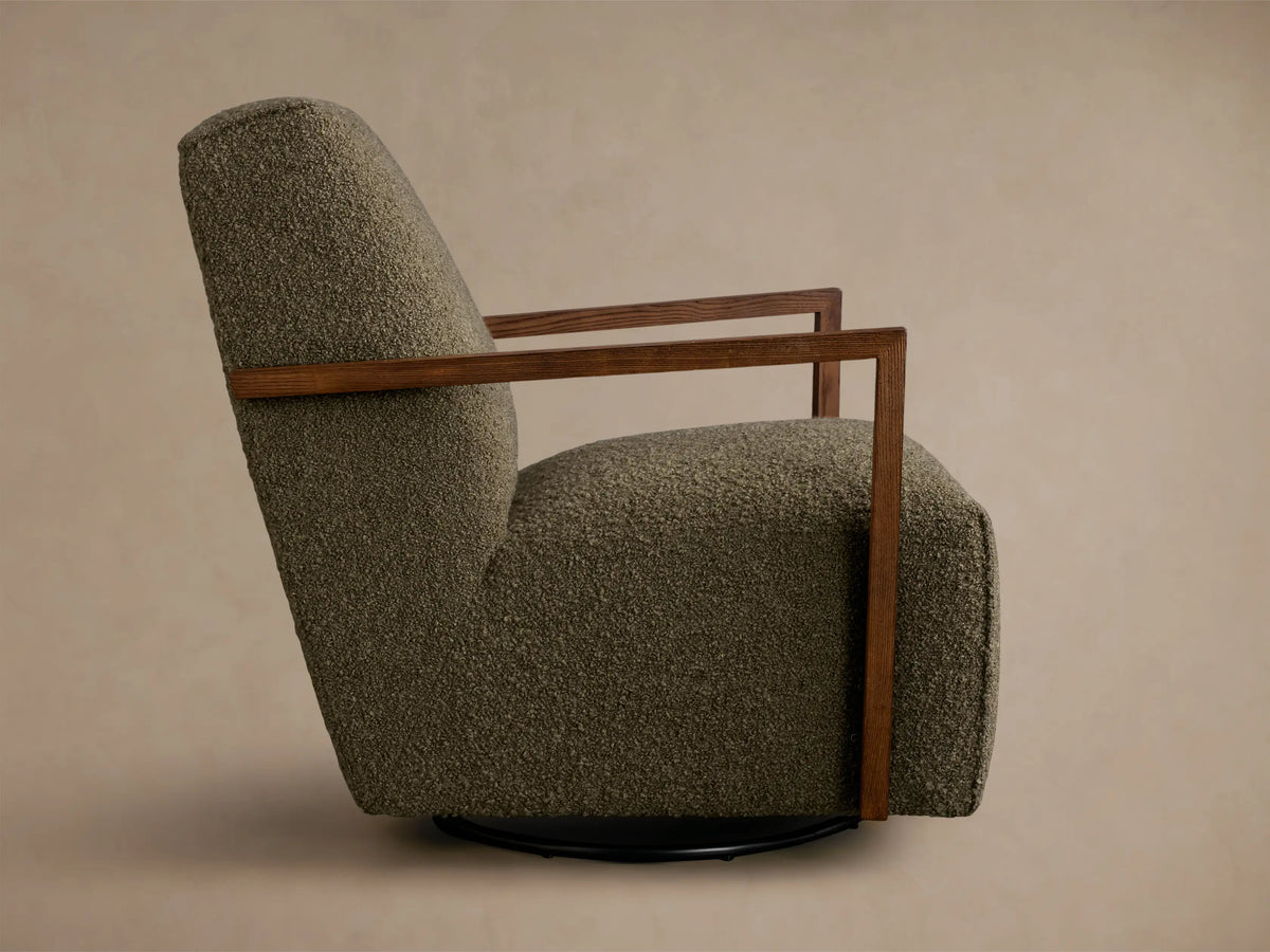 Rear view of an olive green textured Walsh Swivel Glider with dark wooden armrests and a black swivel base.