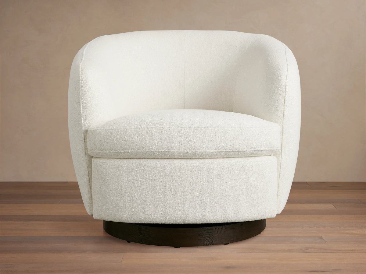 Cerrito Swivel Chair in white fabric, featuring a smooth, rounded backrest and cushioned seat on a dark round swivel base.