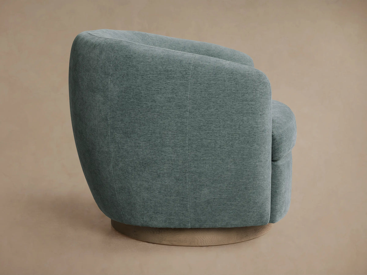 Close-up of a Cerrito Swivel Chair's curved backrest and seat, upholstered in textured greenish-blue fabric.